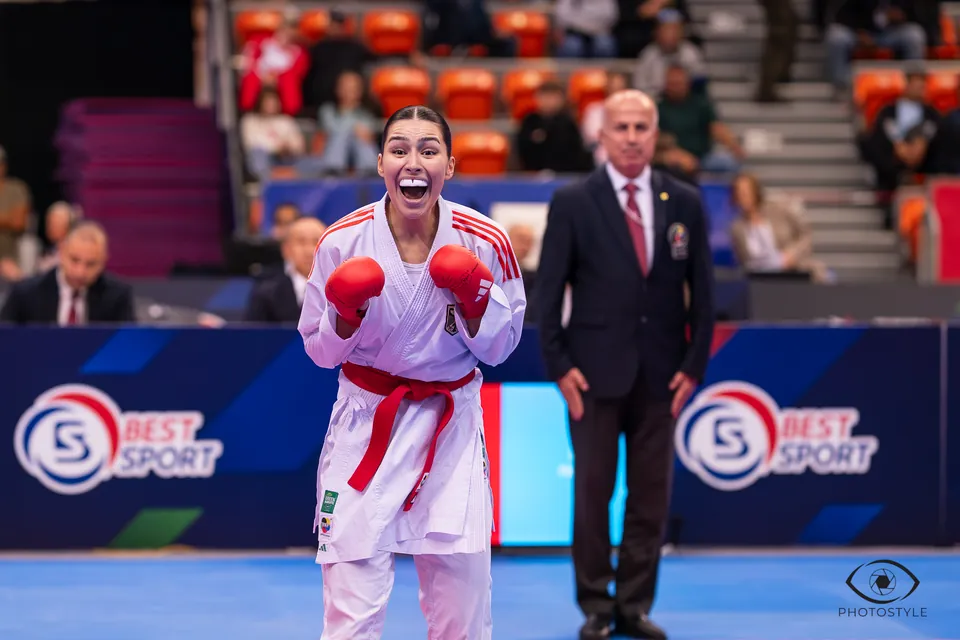 Kumite: an athlete celebrates her win next to the referee