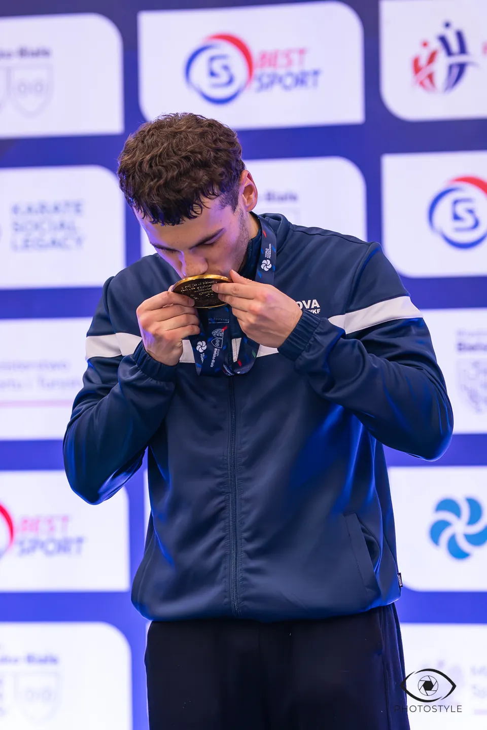 A champion kisses his medal
