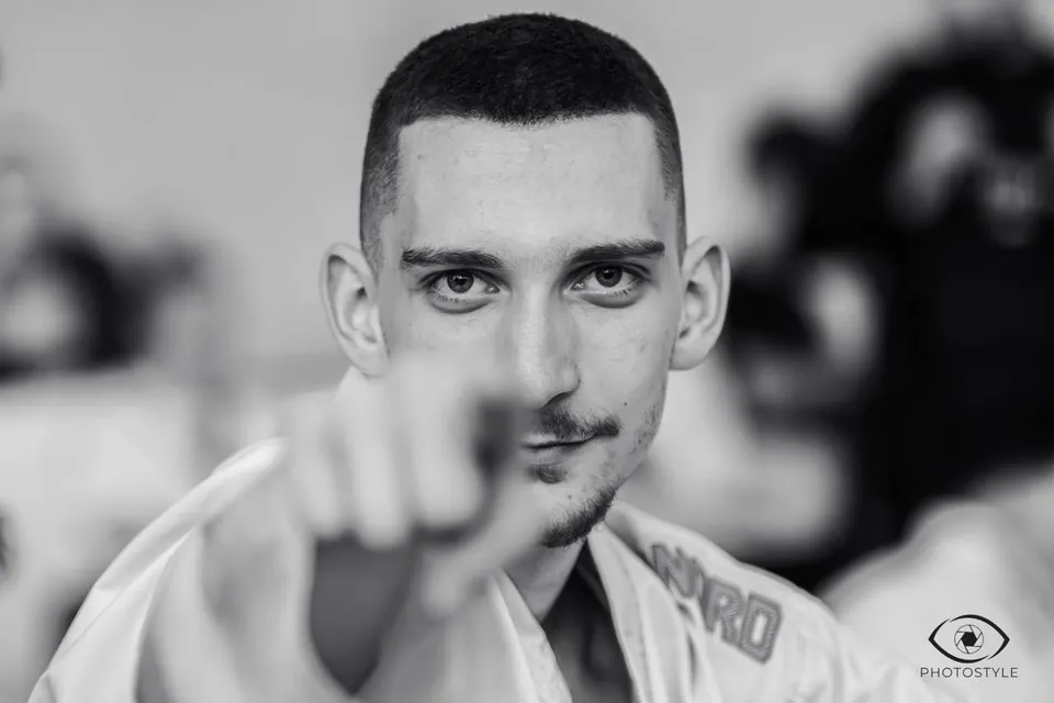 Portrait of a karateka with a fist toward the camera, black and white