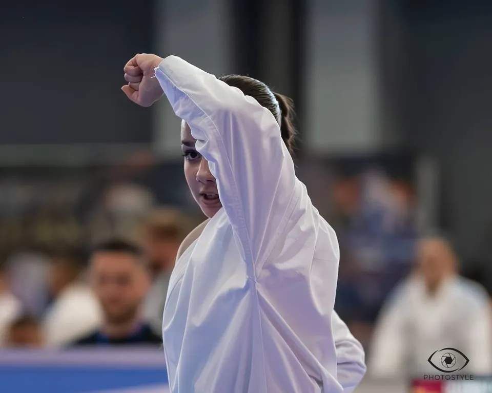 A young karateka in a gi at a tournament